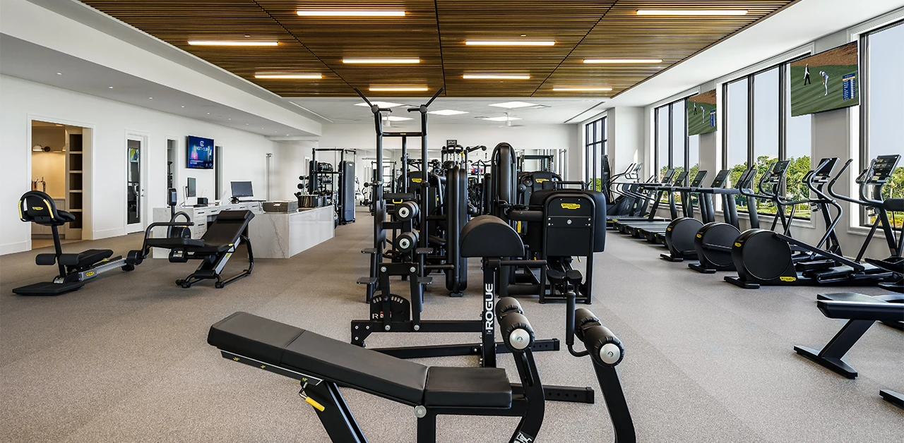 Interior of a modern gym with treadmills and strength-training equipment.