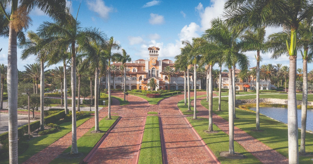 Palm-lined driveway leading to clubhouse entrance